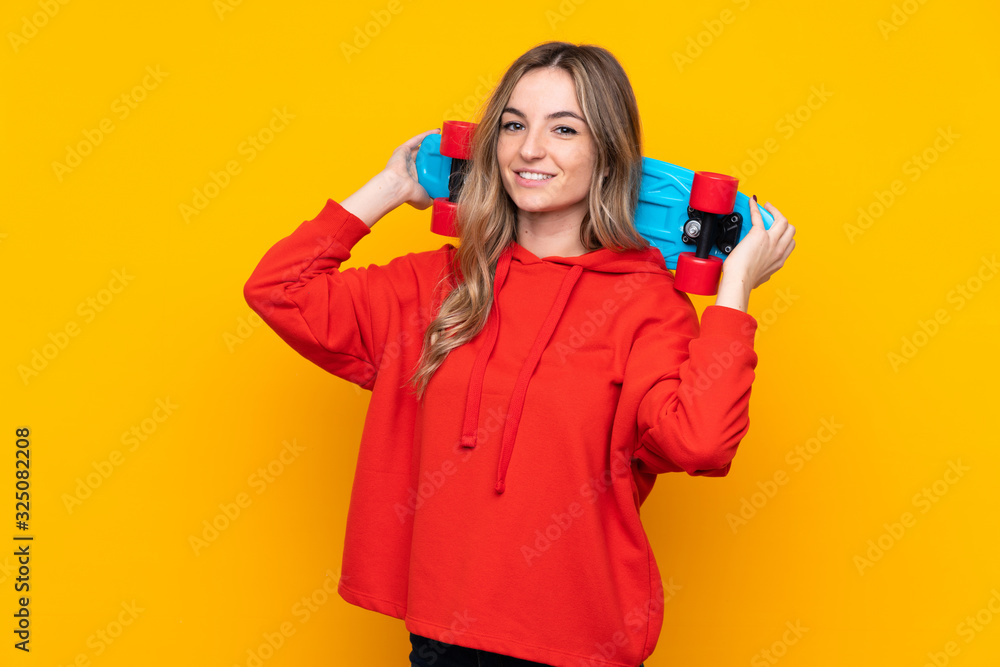 Young woman over isolated yellow background with a skate with happy expression Young woman over isolated yellow background with a skate with happy expression