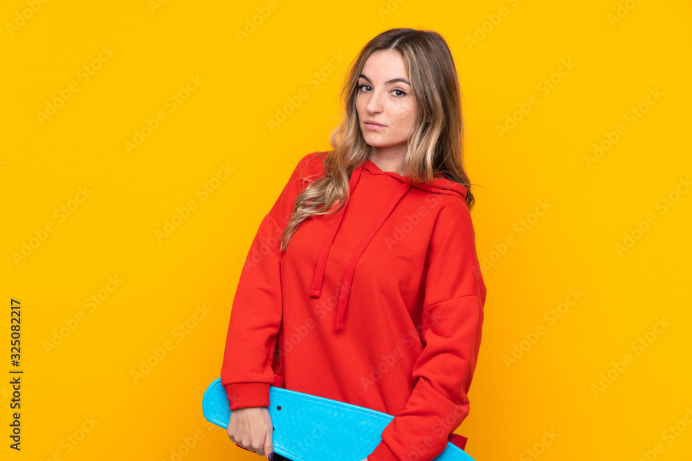 Young woman over isolated yellow background with a skate Young woman over isolated yellow background with a skate