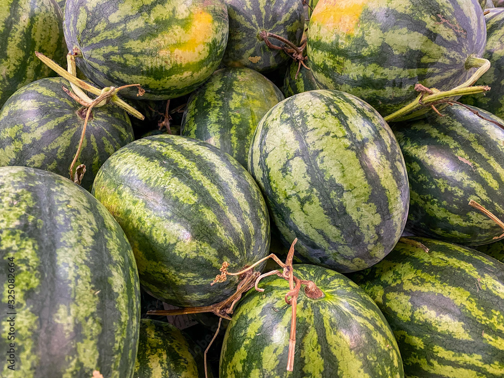 Full frame photo of stripped watermelons at fruit market