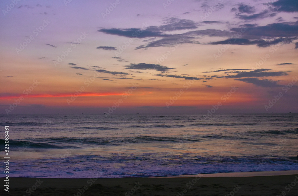 colorful reddish sky over the horizon with layer of sand in foreground
