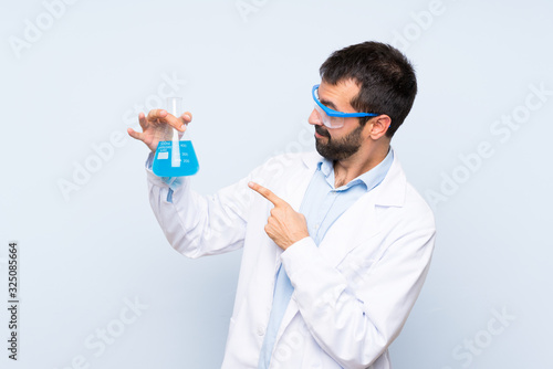 Young scientific holding laboratory flask over isolated background
