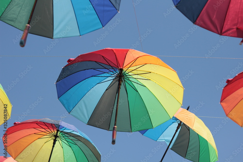 colorful umbrella hang on the air with blue sky background