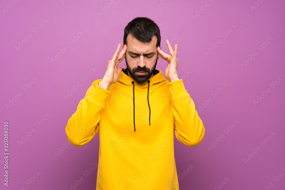 Handsome man with yellow sweatshirt with headache Handsome man with yellow sweatshirt with headache