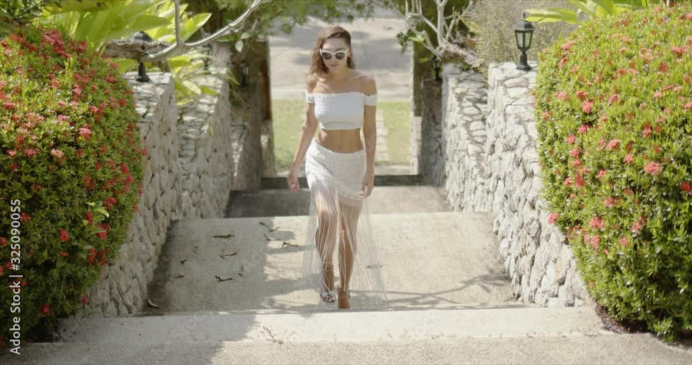 Slim female walking on steps in garden Slim female walking on steps in garden
