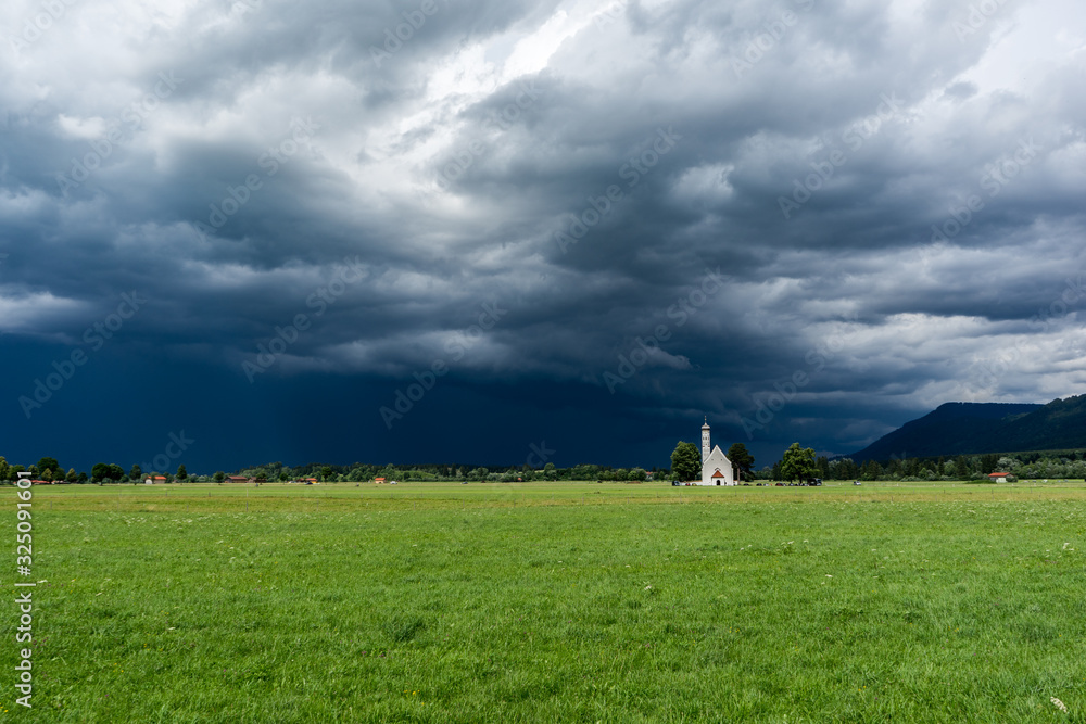 Dramatic black clouds above a cute bavarian chapel Dramatic black clouds above a cute bavarian chapel
