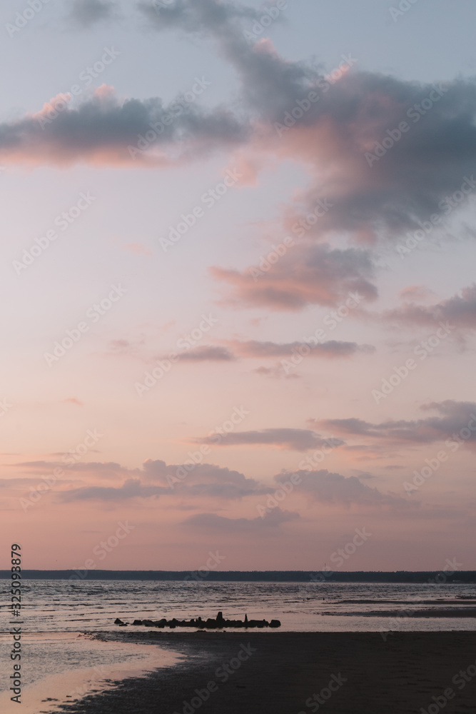 Calming scenic landscape above the sea. Gentle tones of the scenery. Pinky tones of sky. Travel and vacation. Natural background concept. Inspirational vertical photo.