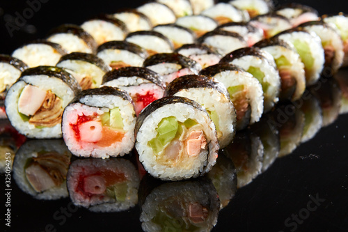 Various kinds of sushi roll set served on black stone. Japanese food
