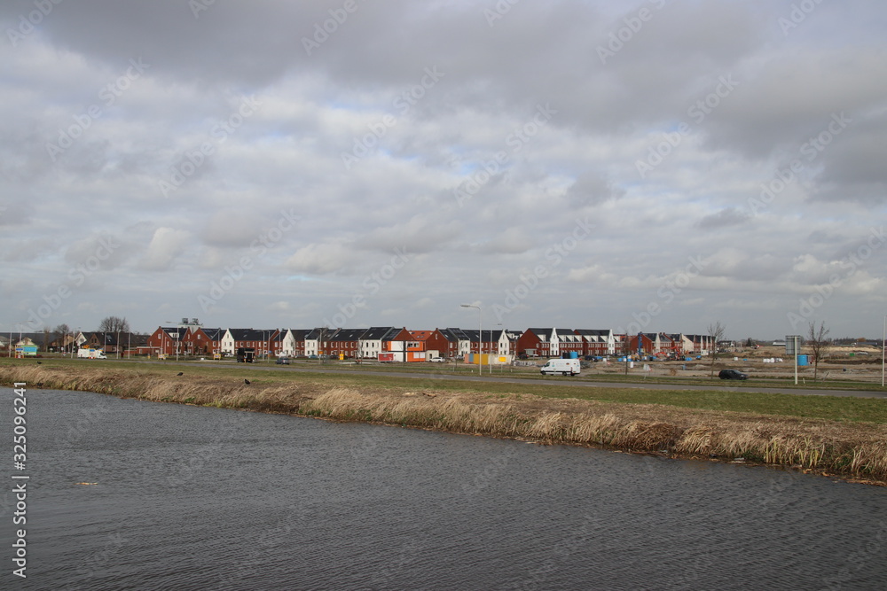 water of the ringvaart Zuidplaspolder with on back the new residential district Koningskwartier in Zevenhuizen water of the ringvaart Zuidplaspolder with on back the new residential district Koningskwartier in Zevenhuizen