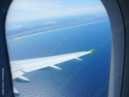 Air travel. Blue sea under the airplane wing