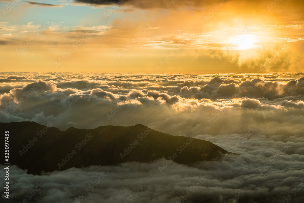 Sunset light above fluffy clouds in alps mountains, France Sunset light above fluffy clouds in alps mountains, France
