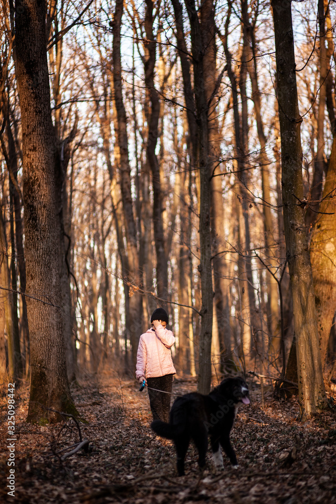 Girl and dog walk in the forest