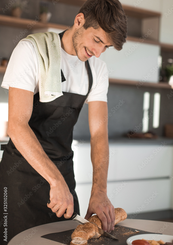 young man preparing a sandwich in the kitchen young man preparing a sandwich in the kitchen