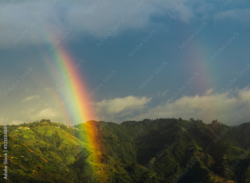Wonderful landscape of a mountain with two rainbows in Bello, Colombia with a beautiful blue sky. Wonderful landscape of a mountain with two rainbows in Bello, Colombia with a beautiful blue sky.