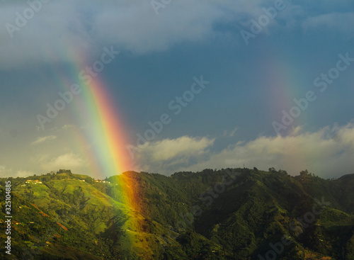 Wonderful landscape of a mountain with two rainbows in Bello, Colombia with a beautiful blue sky.