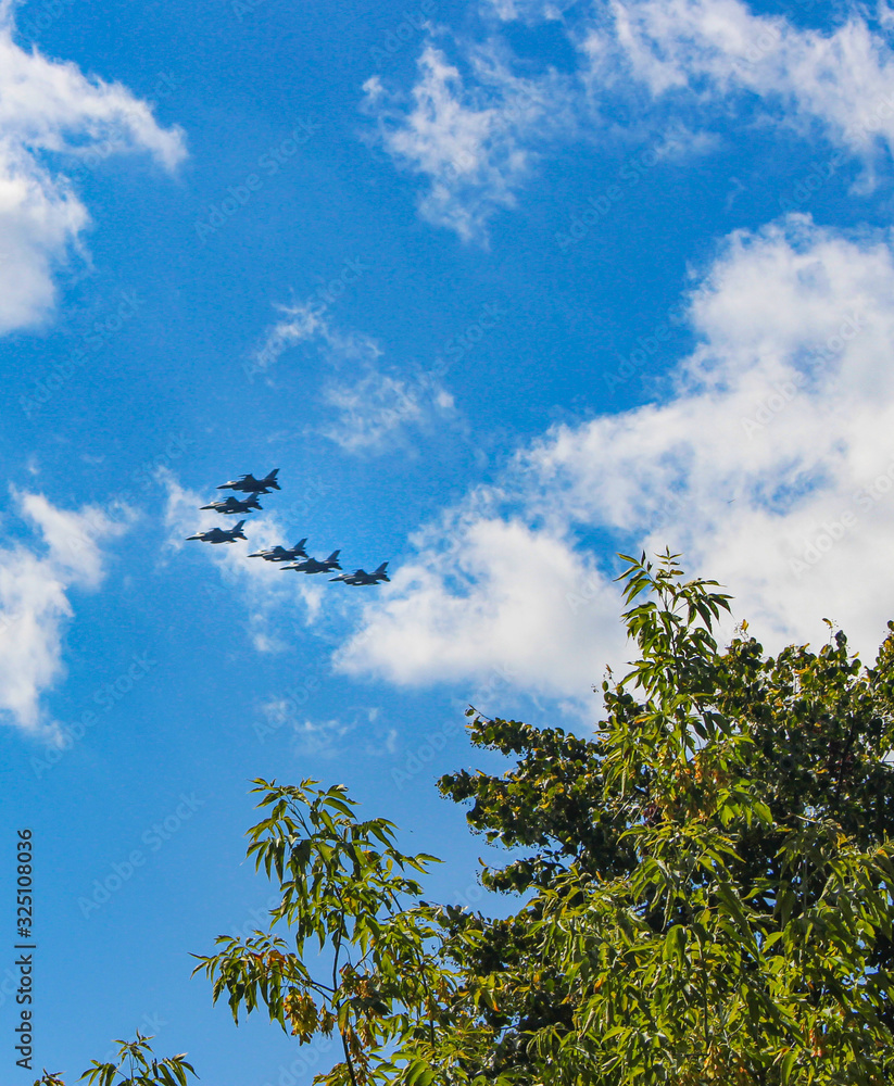 a group of fighters is flying over the city a group of fighters is flying over the city