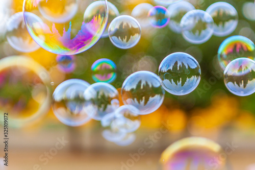 Un grande gruppo di bolle di sapone vola in aria, sfondo sfocato effetto bokeh