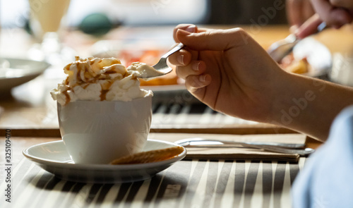 Cuadro en lienzo chica joven tomando un café con nata montada en un resturante con luz natural