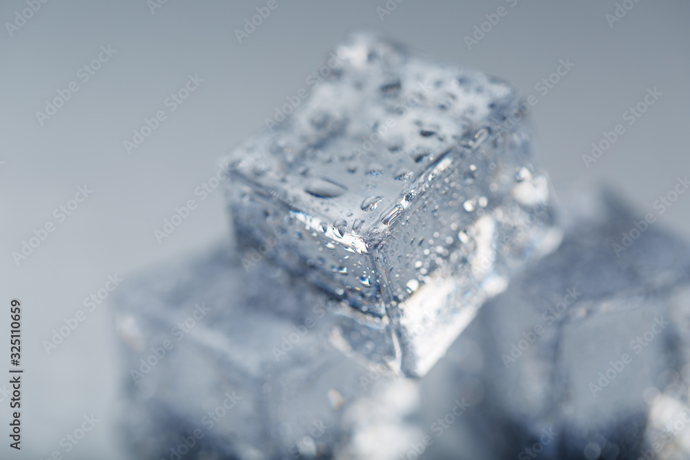 Ice cube with water drops close - up in macro on a white background. Refreshing ice. Isolate Ice cube with water drops close - up in macro on a white background. Refreshing ice. Isolate