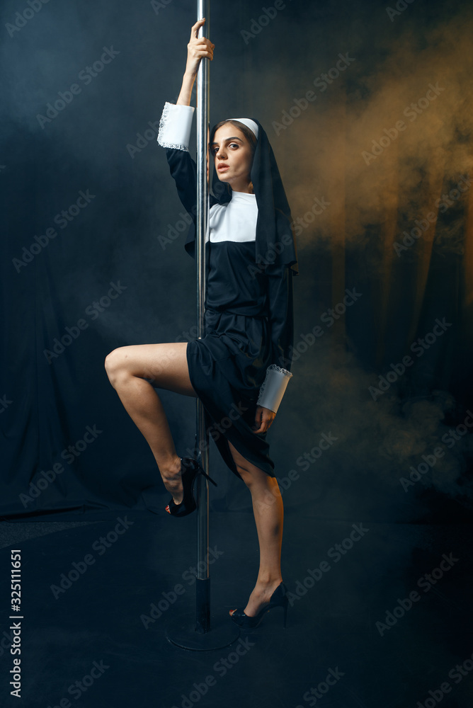 Sexy nun in cassock dances on pole like a stripper