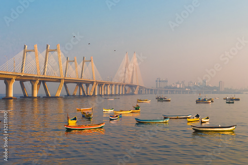 View of Worli sea-link with boats in golden glow of early morning  photo