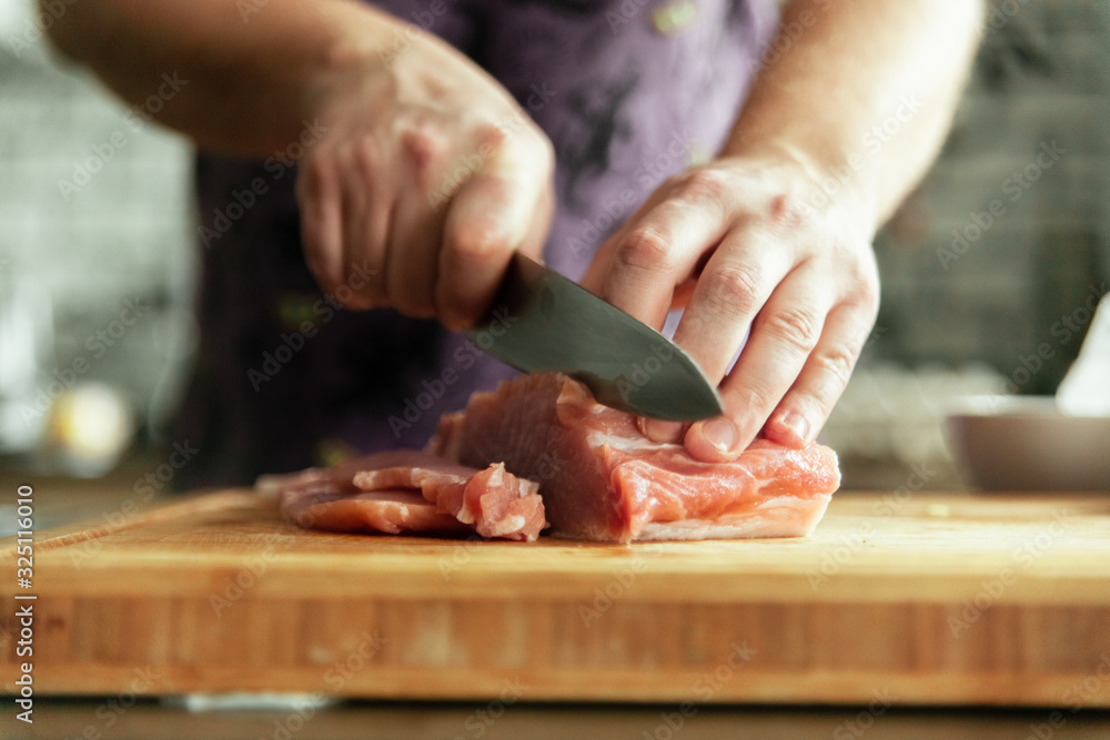 chef cutting meat on board