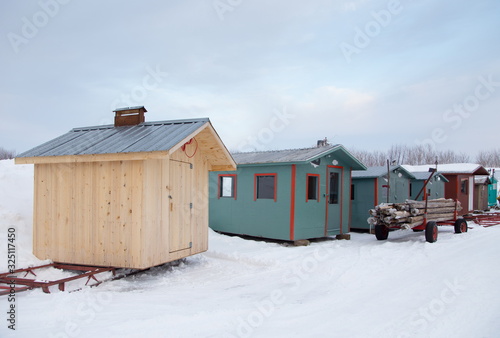 Row of small huts for ice fishing seen during an early winter morning in Sainte-Anne-de-la-Pérade, Québec, Canada