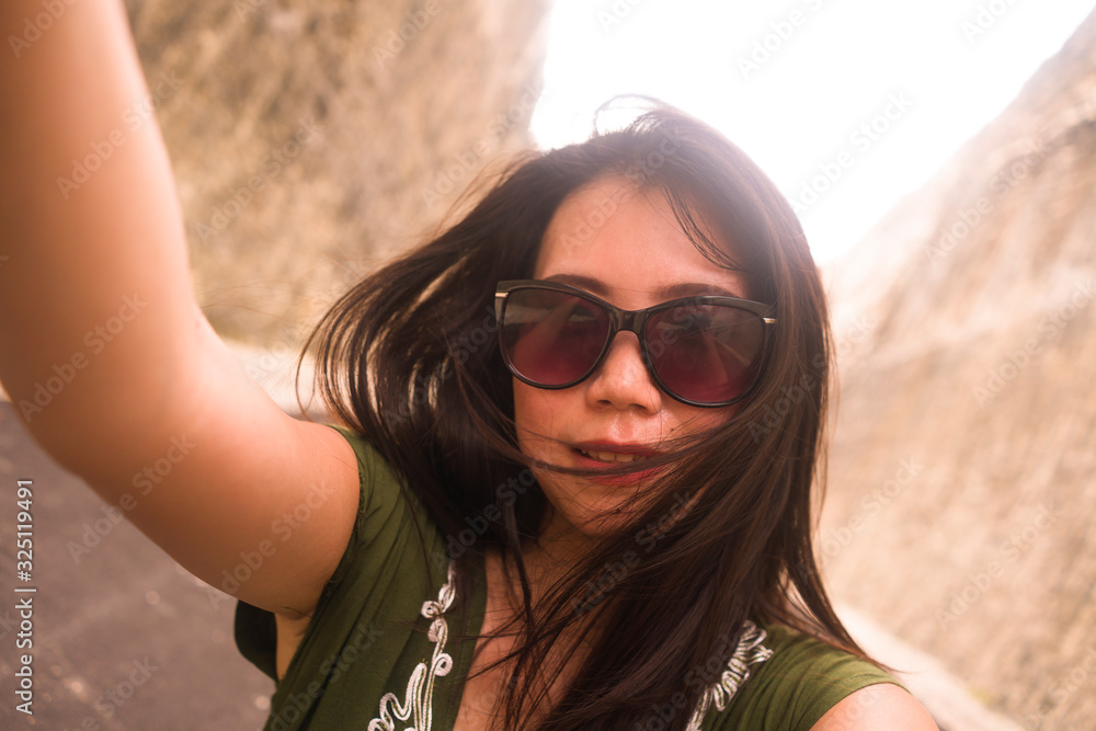 young happy and beautiful Asian Korean Chinese taking selfie photo with mobile phone posing playful and carefree in sunglasses enjoying Summer holiday trip