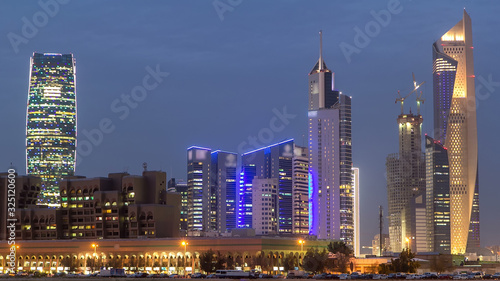 Skyline with Skyscrapers day to night timelapse in Kuwait City downtown illuminated at dusk. Kuwait City, Middle East © neiezhmakov