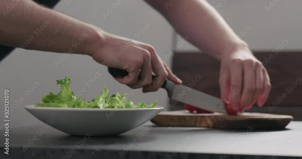 Slow motion tomatoes cut to make salad in white bowl Slow motion tomatoes cut to make salad in white bowl
