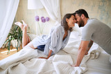 couple cuddling  in the morning while making the bed. bedroom, morning,  togetherness, romance concept