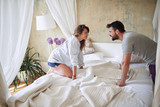 young couple looking at each other over the bed in the bedroom. bedroom, morning,  togetherness, romance, love concept