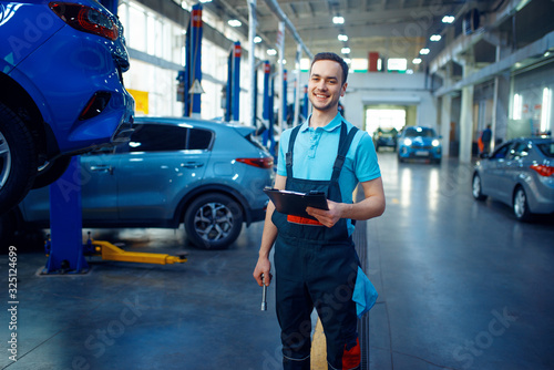Schilderij op canvas Repairman with a checklist, car service station