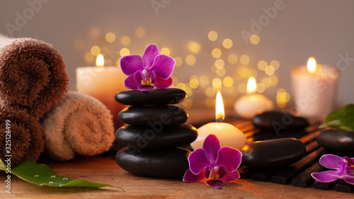 фотография Spa, beauty treatment and wellness background with massage stone, orchid flowers, towels and burning candles
