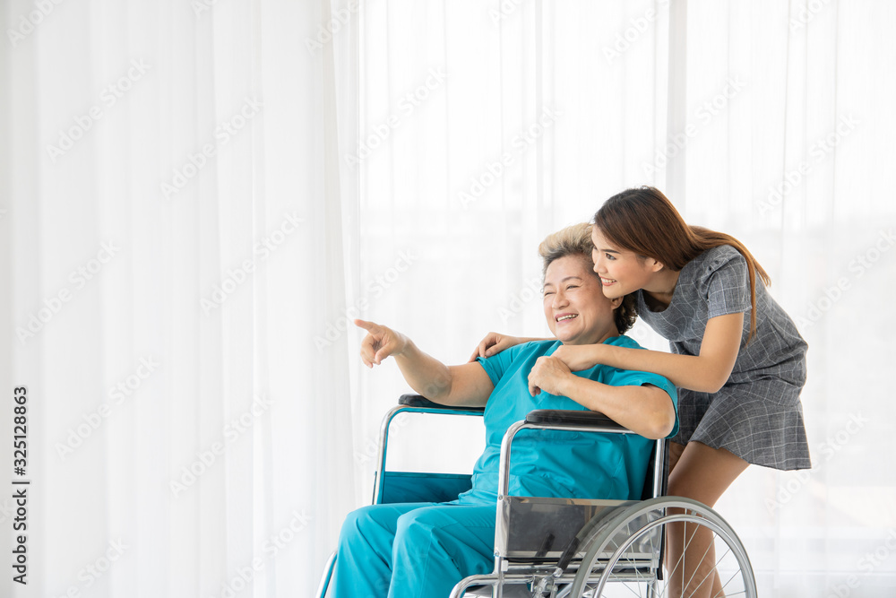 The family visit to embolden the elderly mother who was sick at the hospital. The sick person in the wheelchair was embraced. They have a smiling face. The family visit to embolden the elderly mother who was sick at the hospital. The sick person in the wheelchair was embraced. They have a smiling face.