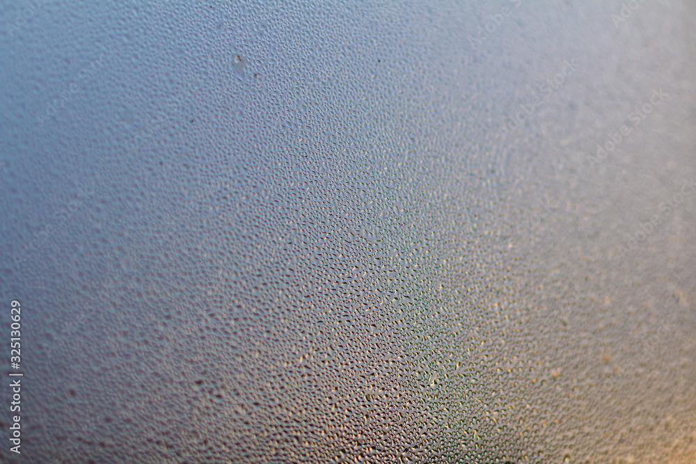 Colorful Rainy background with flowing down water drops on window glass Colorful Rainy background with flowing down water drops on window glass