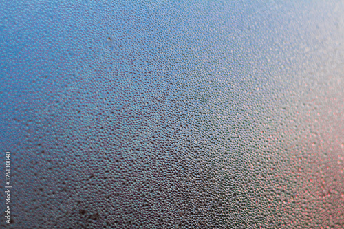 Colorful Rainy background with flowing down water drops on window glass