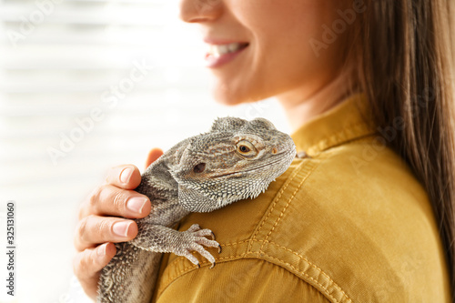 Tableau sur toile Young woman with bearded lizard at home, closeup. Exotic pet