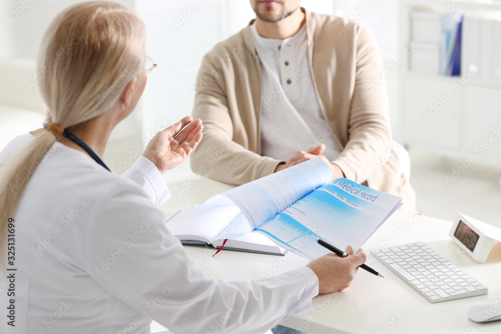 Doctor consulting patient at desk in clinic, closeup Doctor consulting patient at desk in clinic, closeup