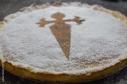 Sweet pie Santiago de Compostela. Santiago tart with sugar powder and cross. Symbol of Camino de Santiago. Homemade almond dessert. Spanish cuisine. Delicious cake.