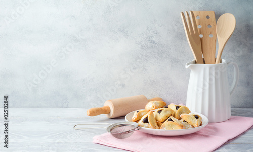 Jewish holiday Purim celebration background with hamantaschen cookies on wooden table. Baking recipe concept. photo