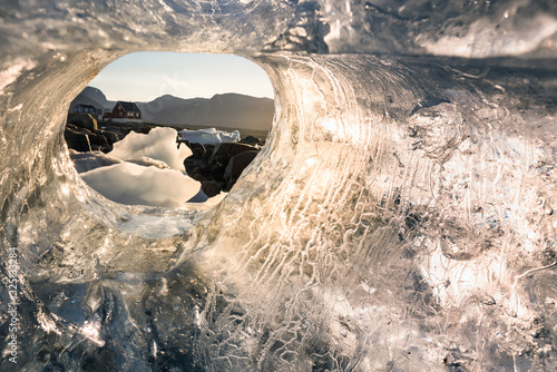 Looking through iceberg at the village of Saqqaq at Disko Bay, Greenland photo