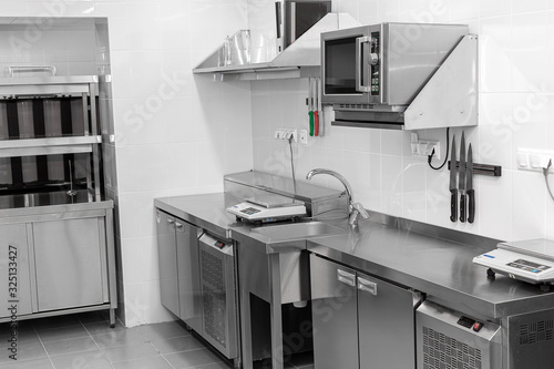 Design of the working area of the commercial cafe kitchen with stainless steel equipments, hot shop, food industry.