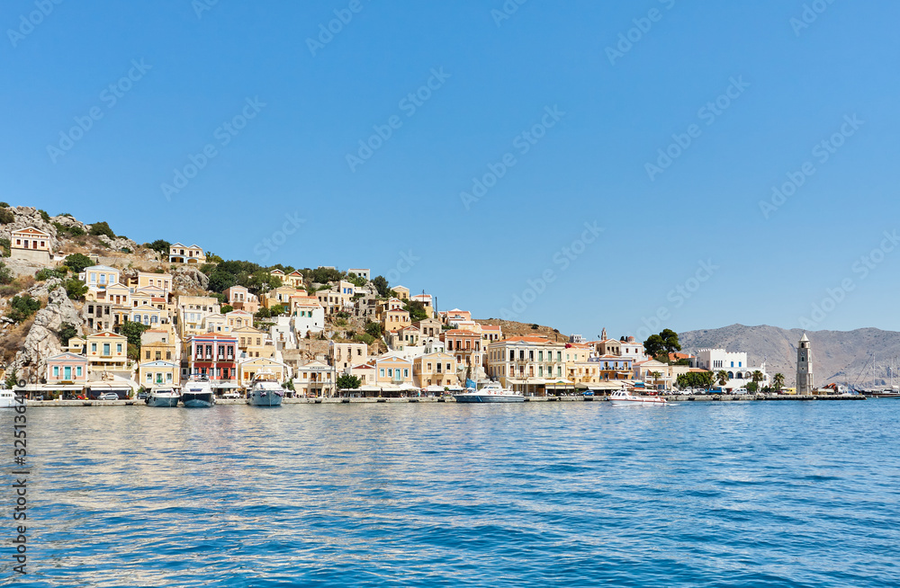 Symi port, Dodecanese islands, Greece, Europe; the picturesque coastline of Symi island with beautiful traditional Greek houses and colorful buildings