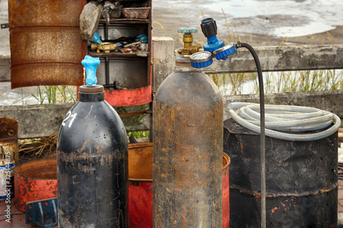 Old rusty gas bottles standing outdoor.