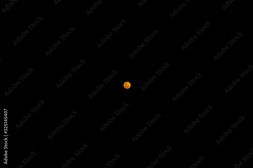 Orange full moon isolated in the sky seen from Kalipur beach in the Andaman and Nicobar Islands of India. Orange full moon isolated in the sky seen from Kalipur beach in the Andaman and Nicobar Islands of India.