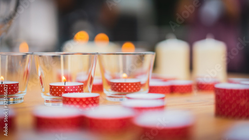 Candles in small little glasses, romantic dinner setting with wedding day concepts.