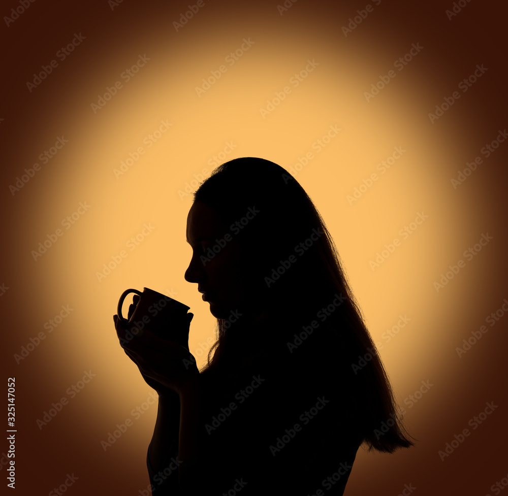 Silhouette of young woman with coffee or tea cup Silhouette of young woman with coffee or tea cup