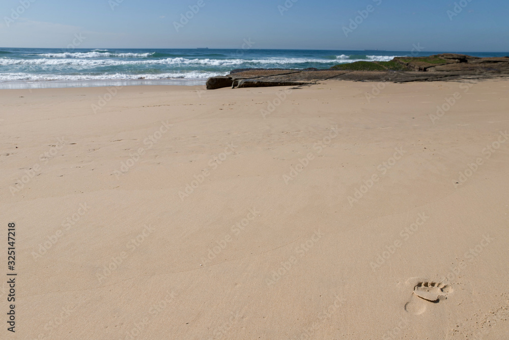 food print on the beach and sea