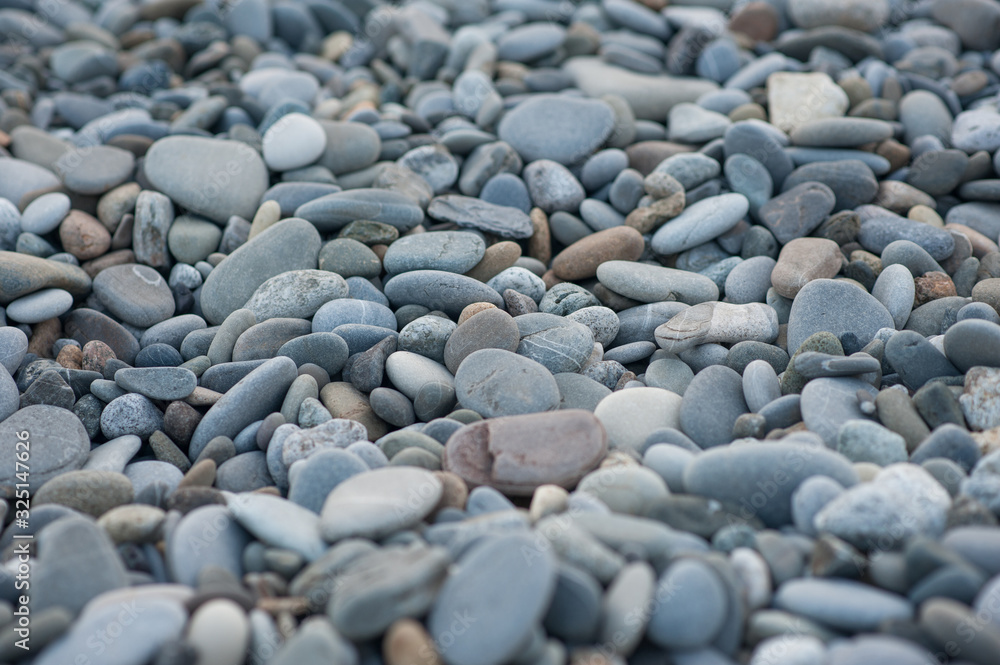 Pebble stones on the shore in sunset light in the background. Pebble stones on the shore in sunset light in the background.