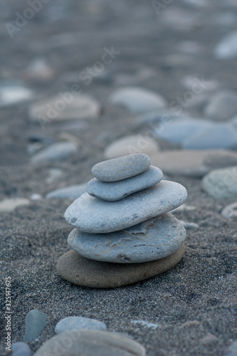 pyramid of stones by the sea at dawn. balanced zen stones. 